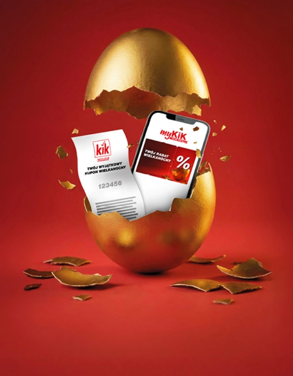 Złote wielkanocne jajko pękło, odsłaniając smartfon wyświetlający promocyjną wiadomość o rabacie wielkanocnym myKiK.