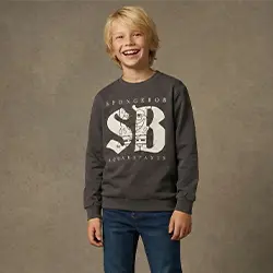 Chłopiec w szarej bluzie i dżinsach uśmiecha się na neutralnym tle. Chłopiec w szarej bluzie i dżinsach uśmiecha się na neutralnym tle.