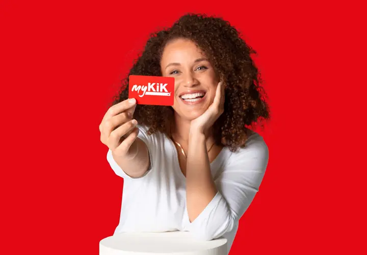 myKiK Osoba z kręconymi włosami trzyma czerwoną kartę myKik na czerwonym tle.