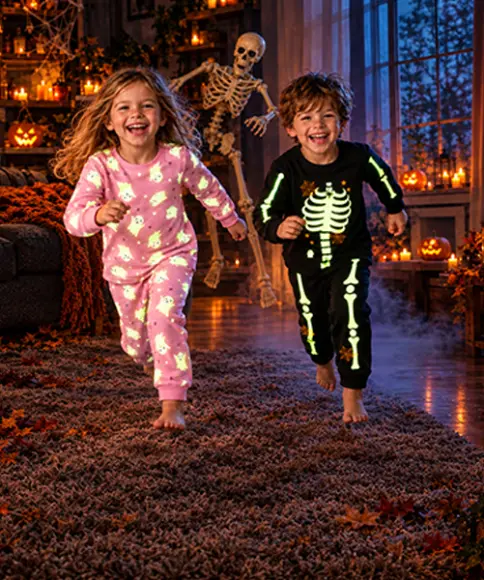 Dzieci w piżamach na Halloween z motywami duchów i szkieletów