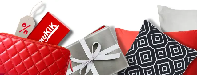 Czerwony portfel z kartą myKiK, prezent w szarym papierze z srebrną wstążką oraz dekoracyjne poduszki