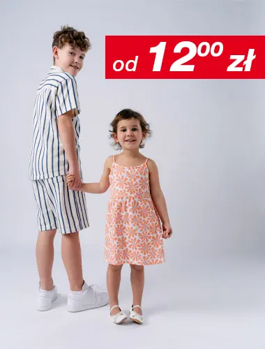 Chłopiec w pasiastym stroju i dziewczynka w kwiecistej sukience trzymają się za ręce, oboje uśmiechnięci, na białym tle.